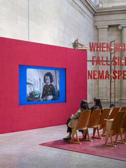 People watching a film in cinema-style seating as part of an installation