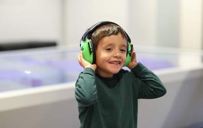 A photograph of a small child wearing ear defenders
