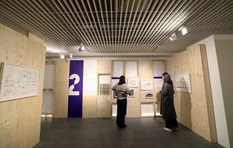 A photograph of visitors looking at artwork at Tate Liverpool + RIBA North