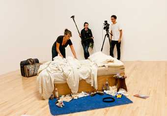 ​Tracey Emin installing My Bed at Tate Britain. Photo by Ana Escoba