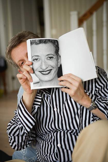 Roni Horn holding up a page from her book Index Cixous Cix Pax 2005