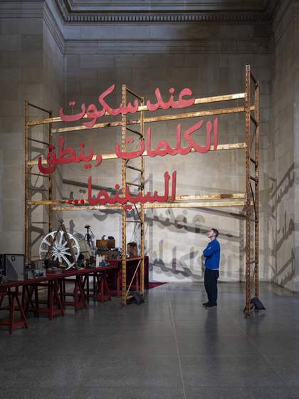 People underneath a large red lettered sign