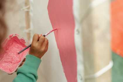 hand of pupil painting a sculpture
