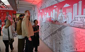 A photograph of a group of people looking at artwork in the Clore Studio at Tate Liverpool