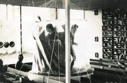 A group of visitors sitting on beams with the threads running across the space