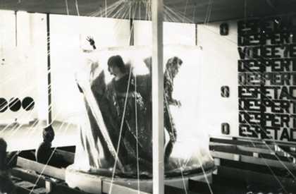 A group of visitors sitting on beams with the threads running across the space