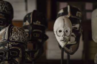 five African masks displayed in an exhibition space