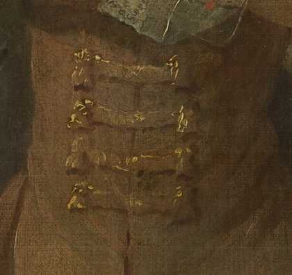 Close crop detail of long fastenings on a piece of clothing, golden brown with bright highlights