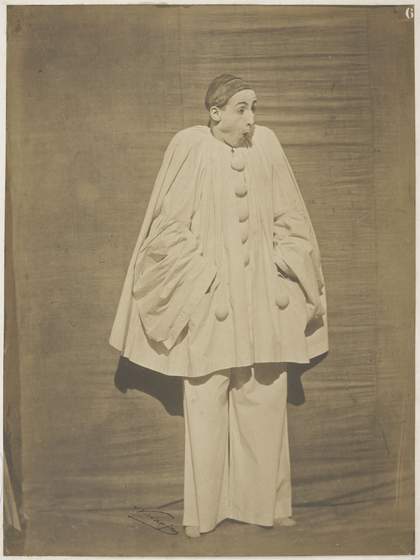 A white clown stands looking surprised
