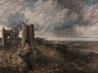 Painting with a ruined castle on a rocky outcrop next to a dark sea. A man and a dog stand on the outcrop in the foreground on the left. The sky is filled with clouds.