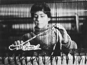 Black and white photograph of Magdalena Abakanowicz at her loom