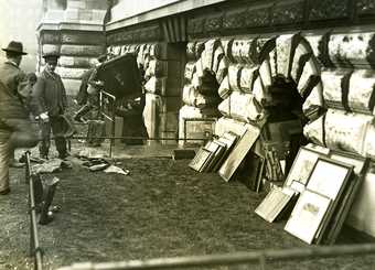 Photo of artworks leaning up against an exterior wall of Tate Britain having been rescued from a flood in 1928.
