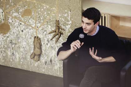 Federico Campagna sits on a chair with a microphone