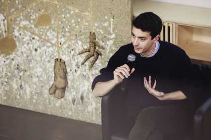 Federico Campagna sits on a chair with a microphone