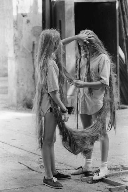 image of two young twin girls attached to each other by their long hair