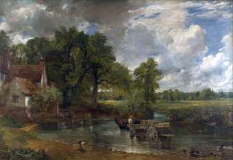A painting of three horses pulling a large wooden cart across a shallow curve of a river towards a cottage on the left. Trees rise behind the cottage, and the sky above them changes from grey cloud on the left to blue on the right.