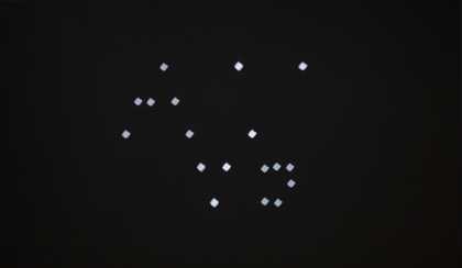 A black rectangle with small white diamond shapes, like a constellation of stars or a kind of visual score