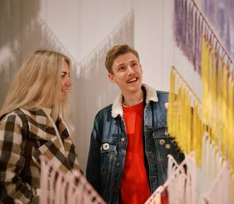 Two visitors enjoying the Outi Pieski exhibition