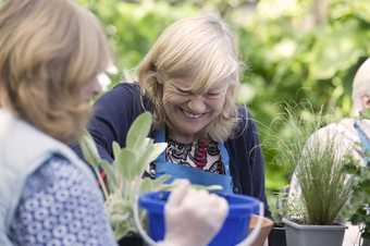 Visitor enjoying planting at Talking Garden event, in the sculpture garden at the Barbara Hepworth Museum