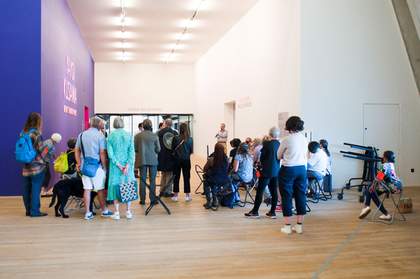 A group of people are standing outside the entrance to the Kusama in America display in Tate Modern