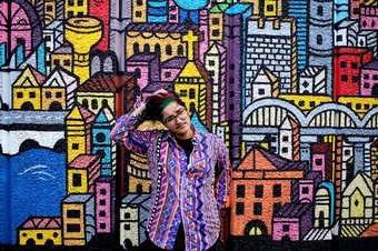 Soofiya in front of colourful cityscape drawing