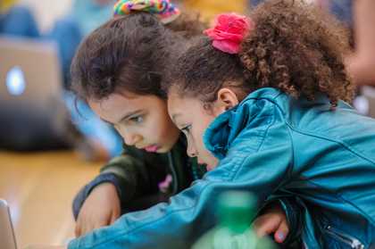 two kids viewing something on screen