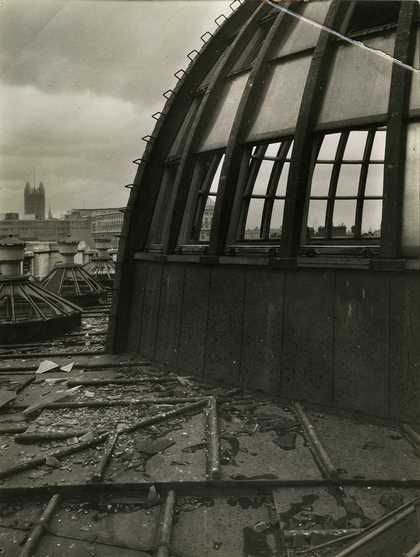 Black and white photo of the bomb damage to the Rotunda roof dome. Their is shattered glass and debris visible.