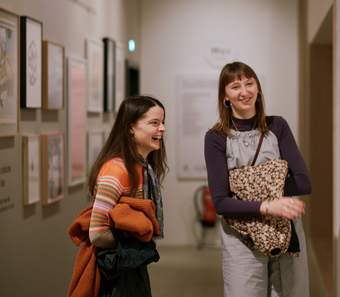 Two visitors laughing in the Outi Pieski exhibition