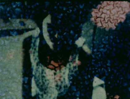 A film still which shows a female sitting with an ornate pattern over the top