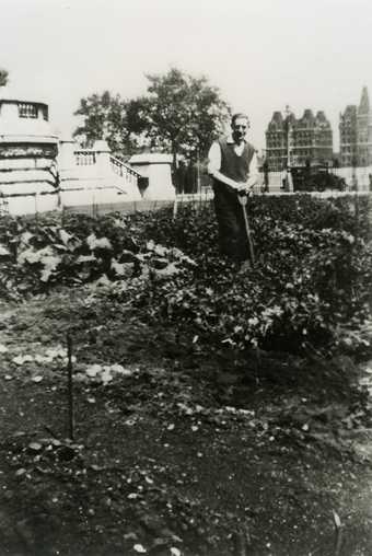 Black and white photo of a man with a spade on an allotment in the Tate Britain gardens.