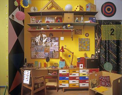 Chapters One to Five, 2012, Production Still of colourful studio with shelves, desk, chair and hanging mobiles 