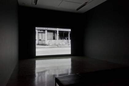 Installation view of John Smith's The Girl Chewing Gum 1976 at Tate Britain, London