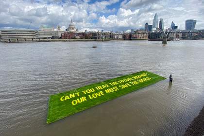 A carpet of false grass floats on the river Thames.