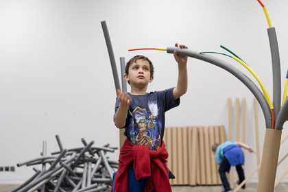 boy making artwork from coloured pipes