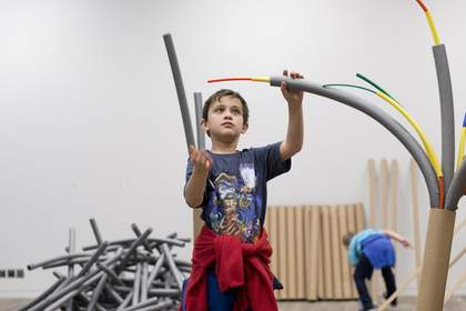 boy making artwork from coloured pipes