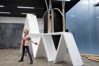 girl standing in front of white geometric sculpture