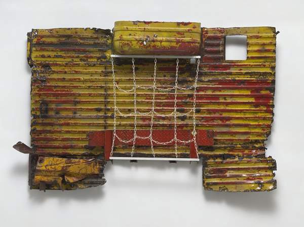 A wall-mounted assemblage of weathered red and yellow corrugated metal, with a hanging grid of chains.