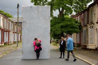 Photograph of people looking at a sculpture