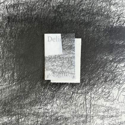 A white space covered in black scribbles with a book in the center