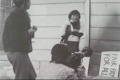 Black and white image of women in a doorway and some protest placards.