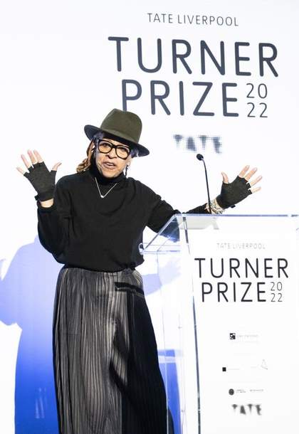 Person standing behind a podium gesturing and talking.