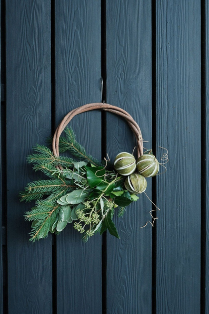 A wreath hung from a dark green wooden door