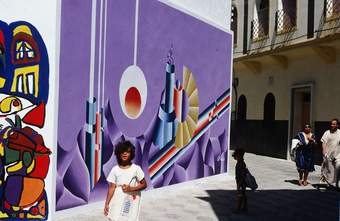 A young girl pictured in front of a colourful abstract mural by Chaïbia and A. Ghattas