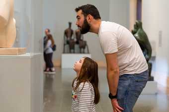 A parent and child looks at a Henry Moore sculpture in Tate Britain