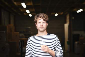 Man with glasses holding a glass of cider