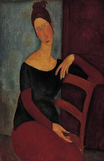 Portrait of Hébuterne sitting sideways, one arm resting atop of the chair. She wears a black low-scooped top, dark red on her arms and lower half. Above an elongated neck, her head tilts dramatically to one side, rosy cheeks. Her dark hair is piled high.