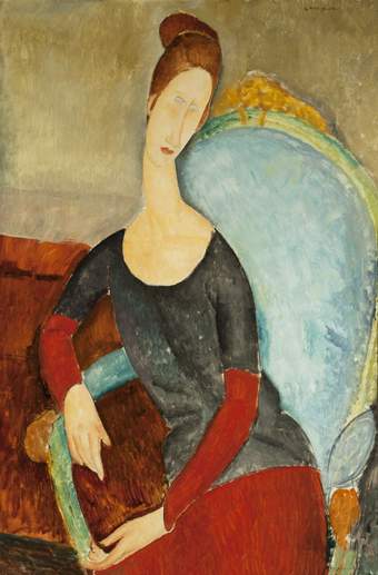 Portrait of Hébuterne sitting in a high-backed pale blue armchair. She leans on her right arm, her head titled to the left. She wears the same clothing as fig.10.