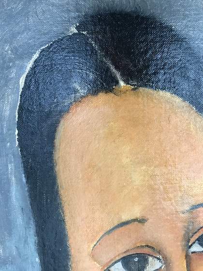A photomicrograph showing where the brush dragged still-wet black paint from the hair into an area of lighter paint, and detail of the figure’s dark hair with a glossy sheen