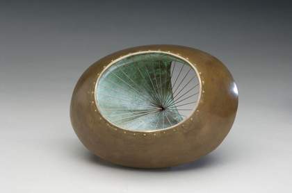 Sculpture with hollowed centre and sides connected with strings.