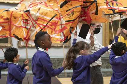 Students marching through Tate Britain with art work created during Artist-led Schools Workshops.